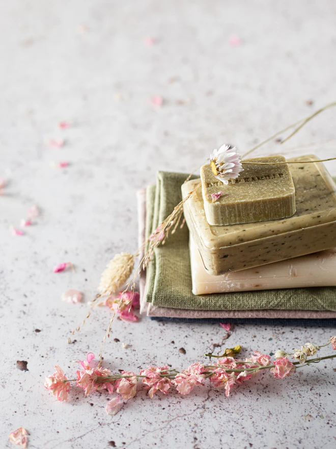 A sage bar on a linen cloth scattered with dried flowers